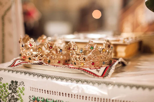 Zbliżenie obrazu ślubów kościelnych koron na stole — Zdjęcie stockowe