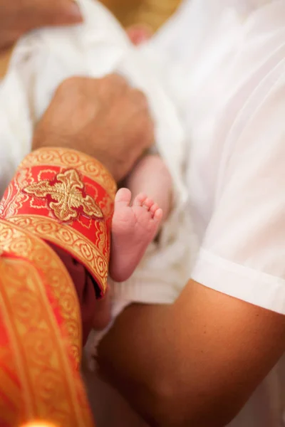 洗礼式、小さな赤ちゃんを持った高僧の手 — ストック写真