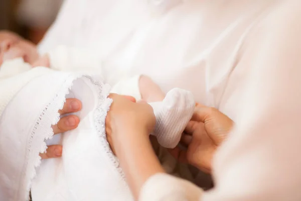 Calcetín blanco en pie de bebé con las manos de la madre cuidando del niño —  Fotos de Stock