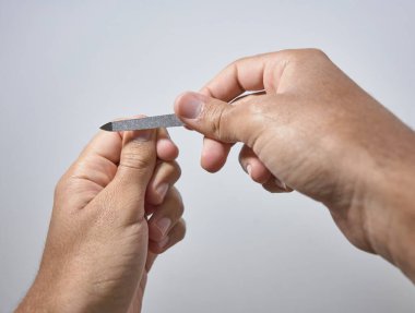 Eller beyaz arkaplanda çivileri törpülüyor