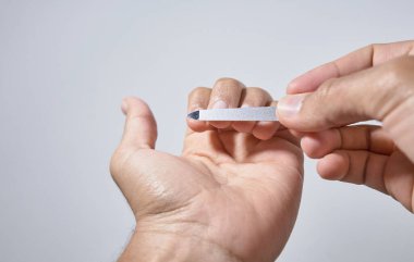 Eller beyaz arkaplanda çivileri törpülüyor
