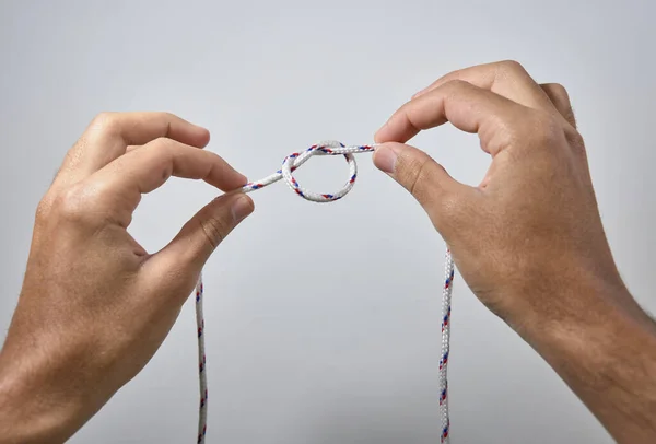 Handen Maken Van Een Knoop Witte Achtergrond — Stockfoto