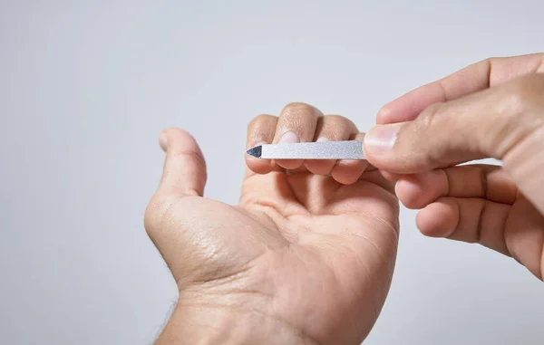 Eller beyaz arkaplanda çivileri törpülüyor