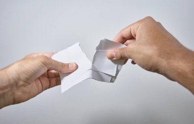 Eller beyaz arka planda kağıt kırıyor.