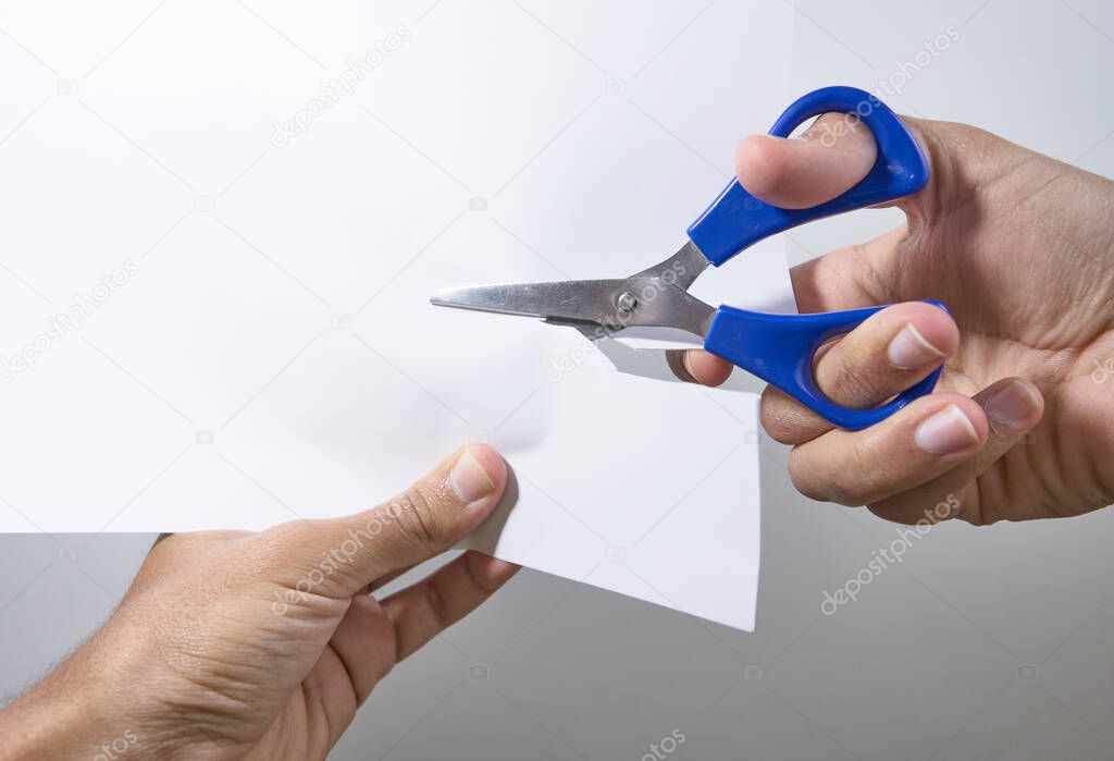 hands cutting a sheet with scissors