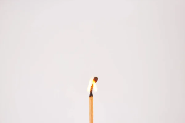 Burning match on white background