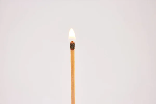 Burning match on white background