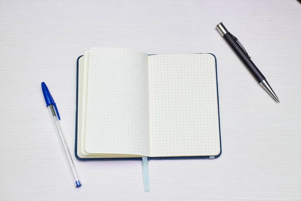 Notatnik Otwarty Długopisami Białym Drewnianym Stole — Zdjęcie stockowe