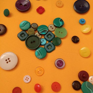 Sarı arka planda yeşil düğmelerin kalbi