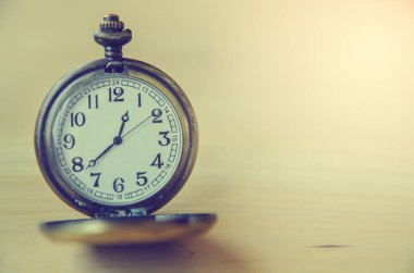 Ahşap masa üzerinde eski cep saati