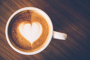 Kahve latte sanat ahşap arka plan üzerinde vintage ile grai kadar yakın