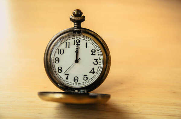 Old pocket watch on wooden table