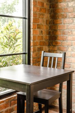 Bir kafe iç. pencere kenarındaki ahşap tablolar. Güneş ışıkları masa ve sandalyeler pencereden girdin. Vintage etkisi.