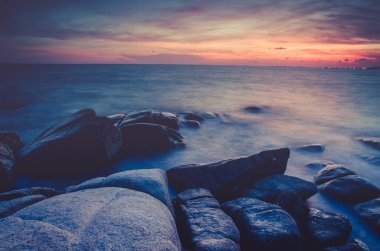 uzun pozlama, güzel deniz manzarası günbatımı veya deniz taş üzerinde güzel bulut scape moody sky Rayong, Tayland, Thailand, güneş doğarken