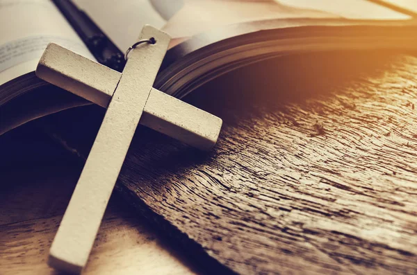 Primo piano della semplice collana croce cristiana in legno sulla Bibbia, tono vintage, dio — Foto Stock