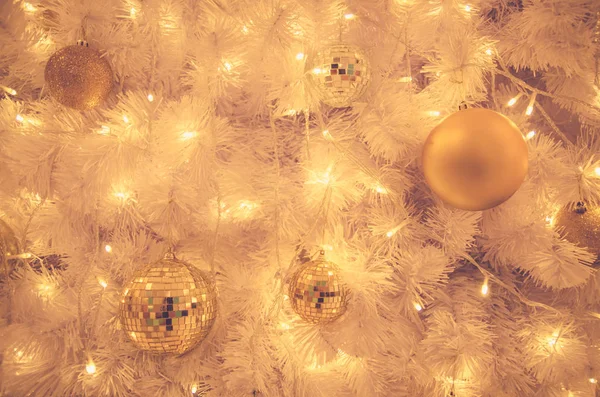 Christmas ornaments gold ball and light bulb on christmas tree — Stock Photo, Image