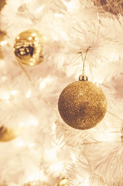 Ornamentos de Natal bola de ouro e lâmpada na árvore de Natal — Fotografia de Stock