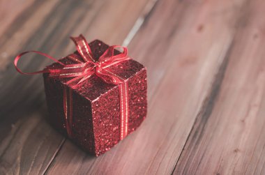  hediye kutusu ve ahşap zemin üzerinde boşluk olan kırmızı kurdele.