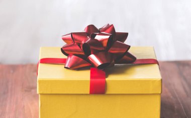 Altın hediye kutusu ve arka planda kırmızı kurdele