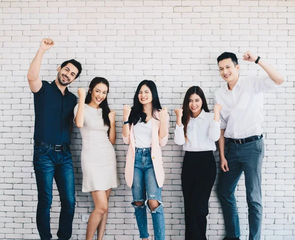 ビジネスチームは 腕を上げて勝利を祝う スマートカジュアルの幸せなビジネスの人々のグループ ストック画像