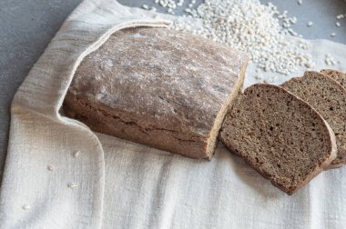 Ev yapımı siyah çavdar ekmeği, açık keten bir peçeteye dilimlenmiş.