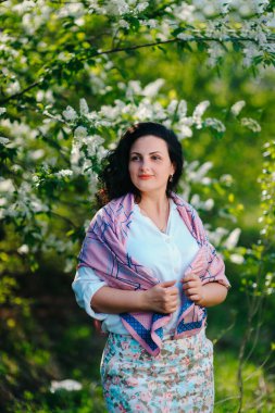 Genç, mutlu ve güzel bir kız model, yazın çiçek açan bahçede.