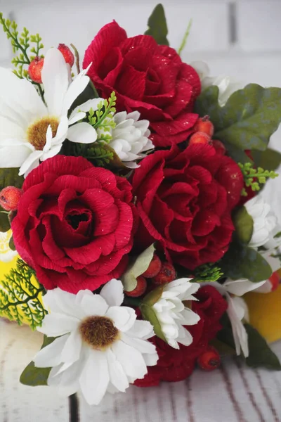Bouquet of artificial maroon roses and white chrysanthemums