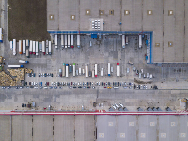 4k Aerial shot of trucks on warehouse parking terminal.
