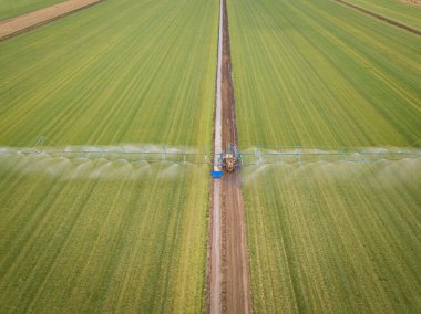 Tarım traktörü ekin tarlasına kimyasal püskürtür. Hava aracı fotoğrafı..
