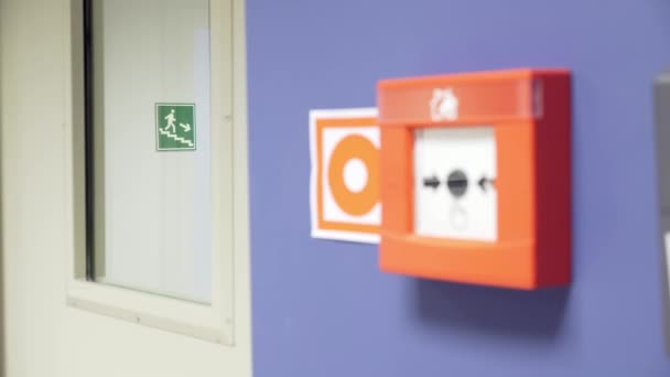 オフィスの階段の火災警報ボタンと出口方向の標識 — ストック動画