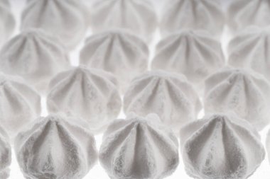 Beyaz kremalı kurabiyelerin arka planı. Tatlı kıtır kıtır kremalı pasta. Çırpılmış yumurta kremalı kurabiye. Şekerli, şekerli, şekerli desen. Boşluğu kopyala, makro, üst görünüm, izole