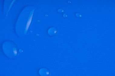 Mavi arka planda kolajen ve peptit içeren serum lekesi örneği. Baloncuklu cilt bakımı jeli. Emülsiyon dokusu. Yaşlanma karşıtı kadın güzellik kozmetik ürünü. Makro