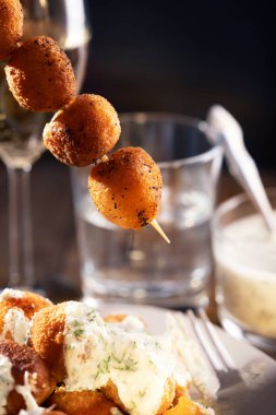 Tzatziki sosunun altına salatalıklı yoğurt ve şişte sarımsak. Kızarmış mozarella peyniri topları mozarella fritta, aperatif. Restoran yemeği. Makro