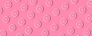 Renkli arka planda portakal dilimleri. Yaratıcı renkli yemek modelleri popüler sanat tarzı. Minimum yaz konsepti. Taze narenciye yerleşimi. Banner, düz yat.