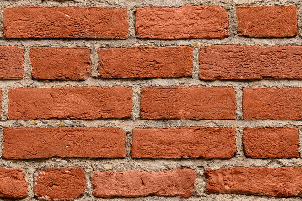 Seamless dark red brick wall texture background for design. Pattern of weathered old cracked brickwall. Stacked stones wall. Brick work wall from old building architecture. Grunge texture background.