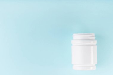 Mavi arka planda şişe maketi. Boş paket, şişe, haplar, kapsüller. Paket konteynırı. Ağrı kesici, vitamin, antibiyotik. Tıbbi tıbbi tedavi konsepti.