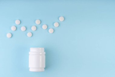 Kardiyogram işareti, ilaç haplarının kalp atışı sembolü. Yaratıcı tablet düzeni ve mavi şişe. Tıp, sağlık hizmeti konsepti. Uzayı kopyala, düz yat