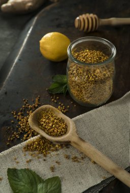 Kavanozda polen, kireç ve nane yaprağı, desenli masa üzerinde.