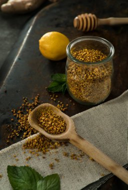 Kavanozda polen, kireç ve nane yaprağı, desenli masa üzerinde.