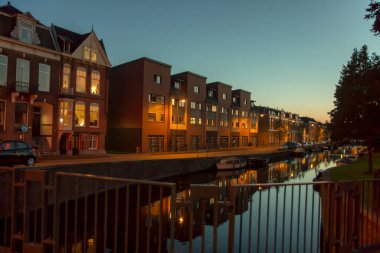 Hollanda, Amsterdam 'da bir kanaldaki evlerin gece manzarası.