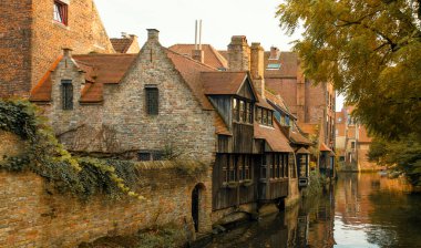 Hollanda, Hollanda ve Belçika 'dan günışığına sahip tipik tuğla ortaçağ evleriyle Bruges kanalının panoramik manzarası