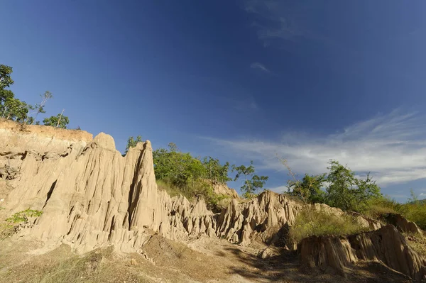 stock image The sand stone or paddy soil very look like little grand canyon,cover with tree and blue sky. The whole place is surrounded with dirt poles and cliffs, which are high.