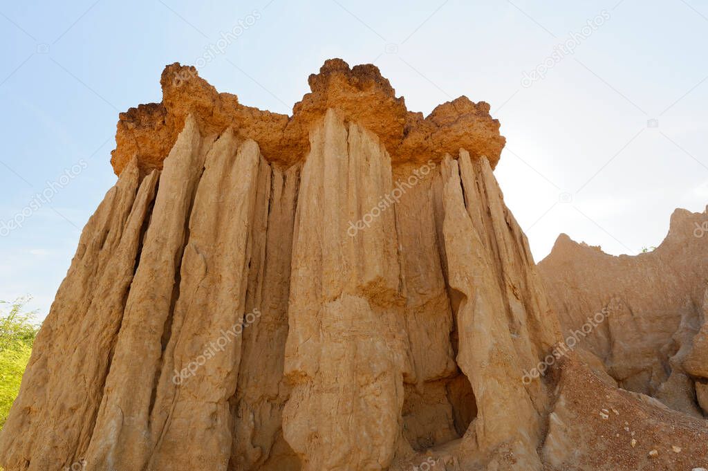 The sand stone or paddy soil very look like little grand canyon,cover with tree and blue sky. The whole place is surrounded with dirt poles and cliffs, which are high.