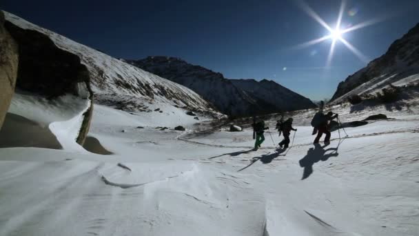 Silhouette di thre uomini con sci in inverno montagne tramonto da vicino . — Video Stock