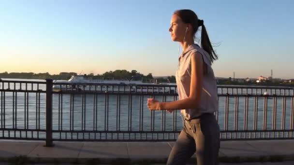 Jovem mulher correndo ao pôr do sol — Vídeo de Stock