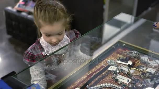 Klein meisje in een juwelier. — Stockvideo