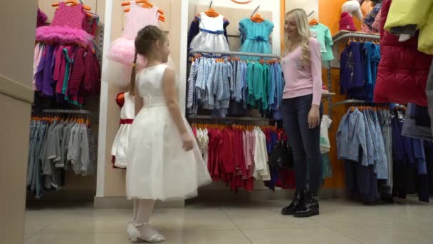 母亲和女儿去逛商场买衣服，在一家服装店, — 图库视频影像