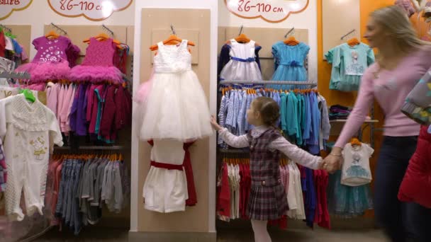 Madre e hija comprando ropa en una tienda de ropa , — Vídeo de stock