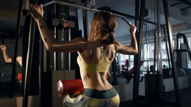 Esmer bir spor salonunda geri esneme aquipment üzerinde kasları.