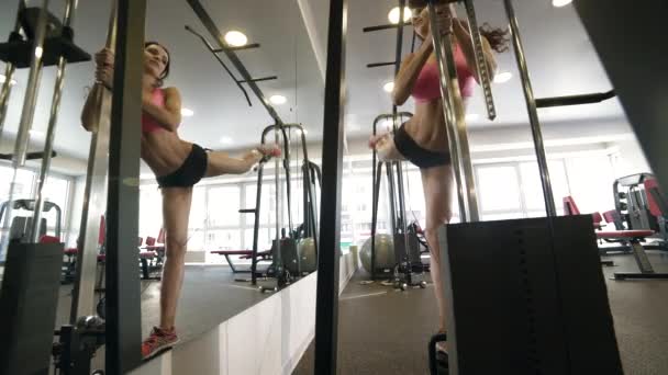 Ragazza che fa esercizio per le gambe sulla stazione fitness in palestra . — Video Stock